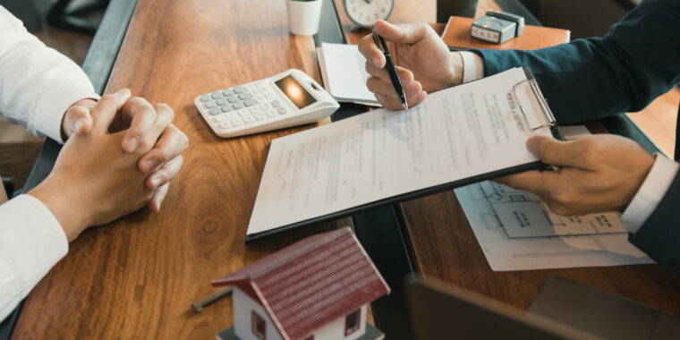 Agents are using pens pointing to contracts and are being explained to customers at the office.