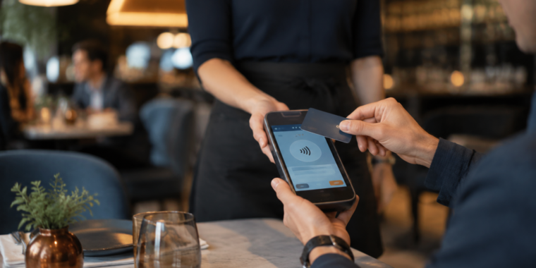 Diner using a contactless card with a handheld restaurant payment terminal
